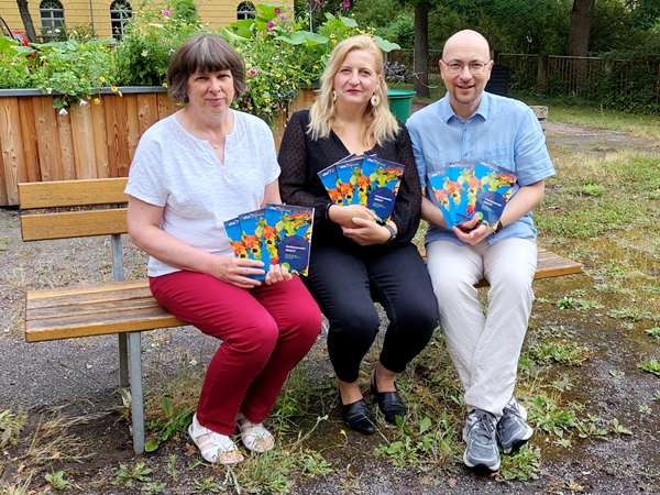 VHS-Leiterin Kristin Treichel (Mitte) und ihre Mitarbeitenden Ute Rüdiger und Dr. Michael Hein präsentieren im „Grünen Klassenzimmer“ der VHS Altenburg das neue Programmheft. (Foto: Kilian Kraus).